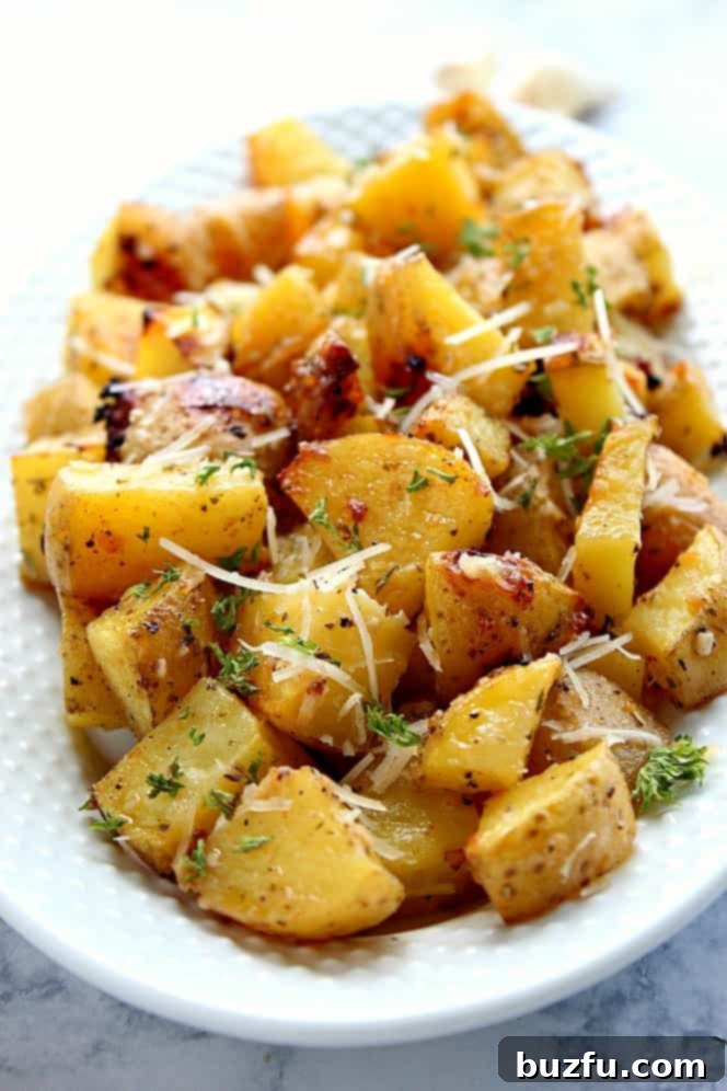Garlic Ranch Roasted Potatoes Recipe - perfectly roasted potatoes with garlic and Ranch seasoning and a mix of butter and oil for the best roasting result. Simple vegetable turned into one delicious side dish! Crispy roasted potatoes with Parmesan cheese and fresh chopped parsley in a white serving bowl, ready to be enjoyed.
