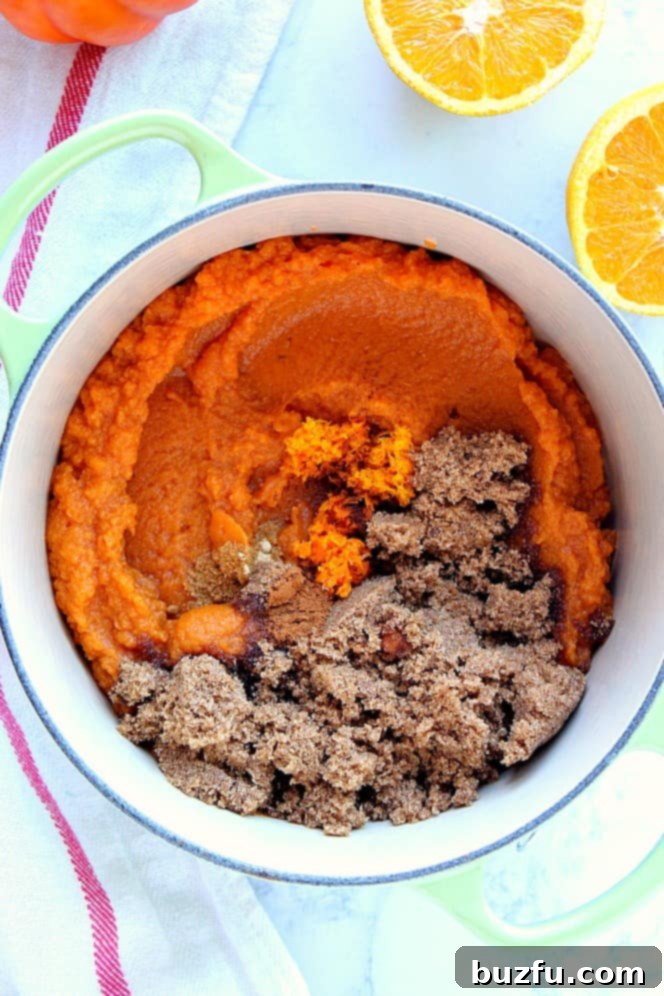 Overhead shot of cast iron saucepan with pumpkin puree, spices and brown sugar, ready to be combined and cooked.