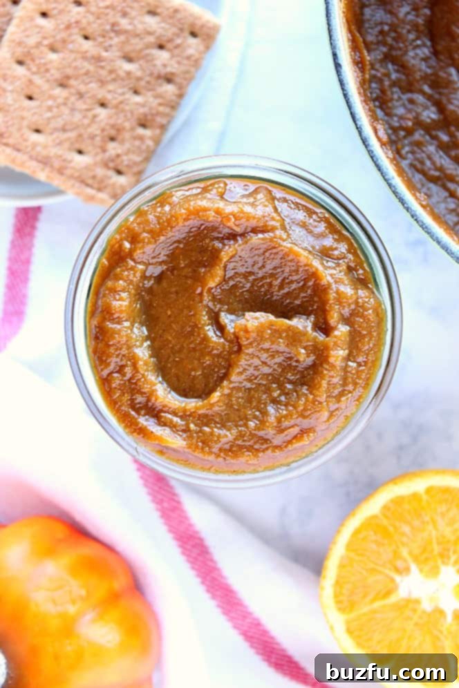 Overhead shot of pumpkin butter in glass jar, perfectly smooth and ready to be used in various fall recipes.