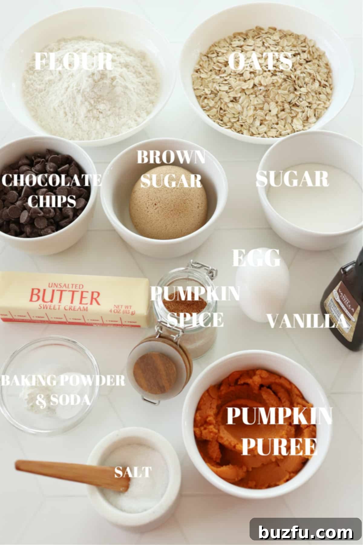All ingredients for pumpkin oatmeal cookies, meticulously laid out on a clean white board, ready for baking.