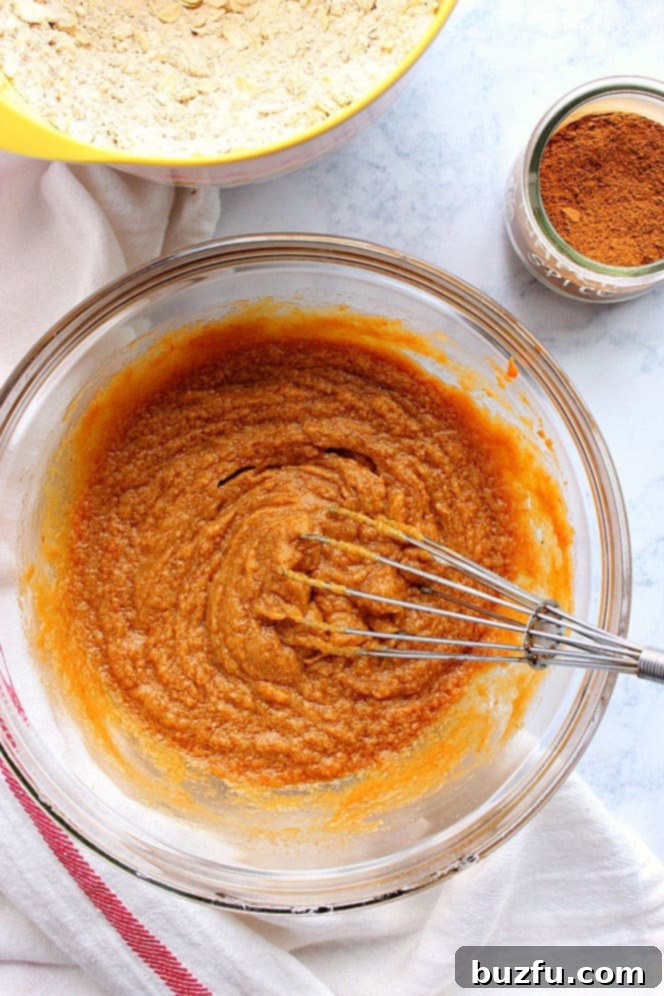 Overhead shot of glass bowl with a smooth pumpkin mixture, ready to be incorporated into the pumpkin oatmeal cookies.