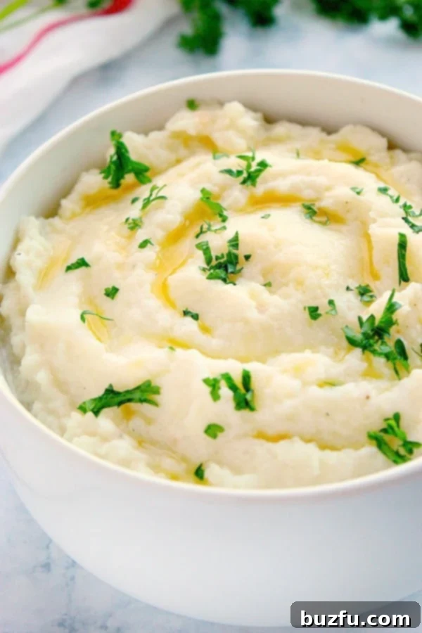 Mashed Cauliflower with chopped parsley in white bowl, ready to be served.