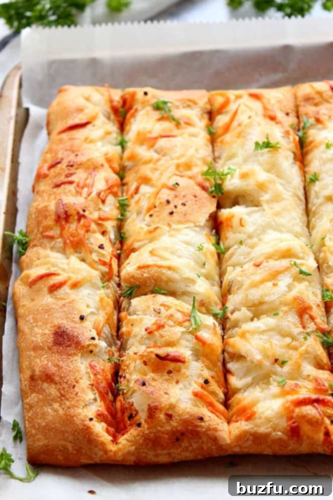 Close up shot of cheesy breadsticks arranged in a pan, showcasing their golden crust and enticing texture.