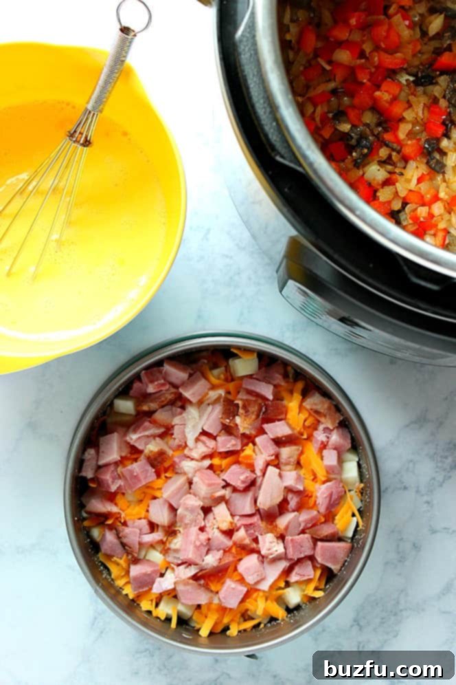 Overhead shot of Instant Pot with sauteed veggies, egg mixture in yellow mixing bowl and cheese and ham layer in springform pan. 