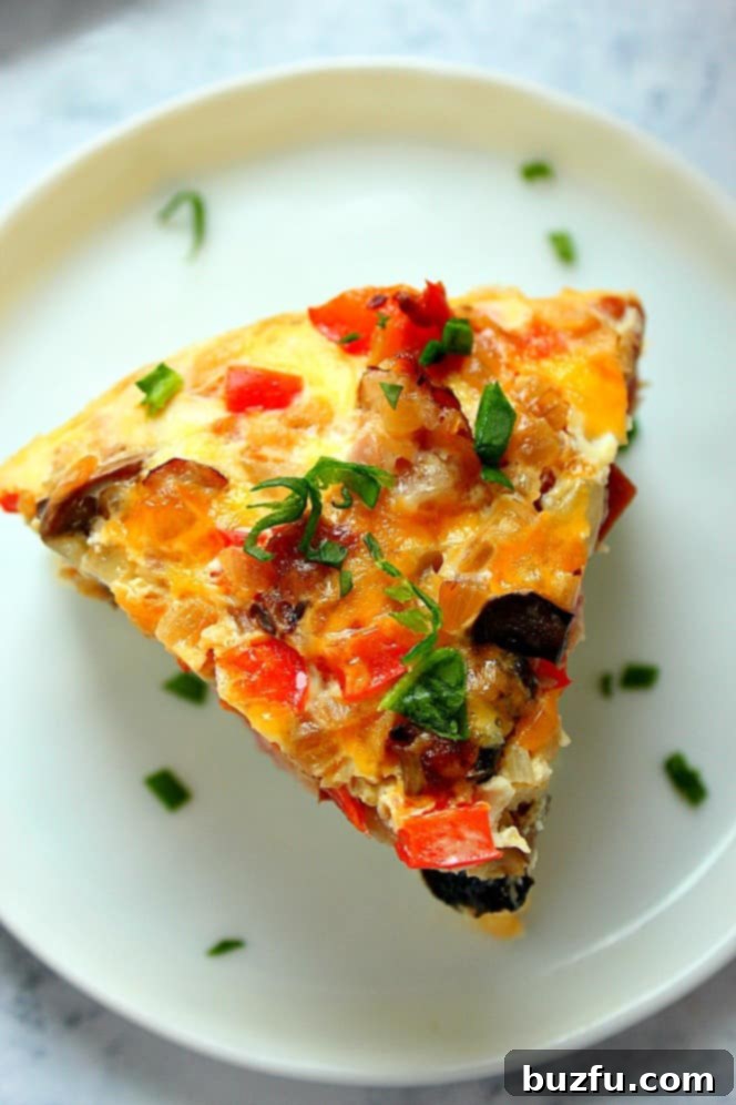Overhead shot of a slice of egg casserole on white plate. 