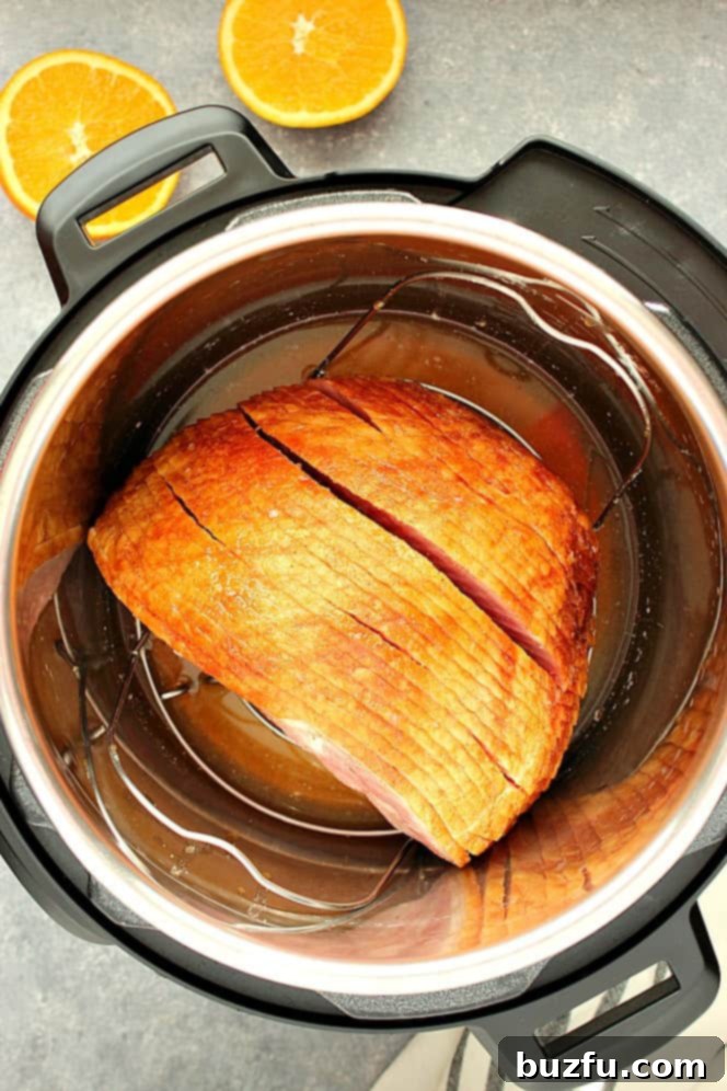 An overhead shot showing a spiral-cut ham nestled on a trivet inside an Instant Pot pressure cooker, ready for cooking.