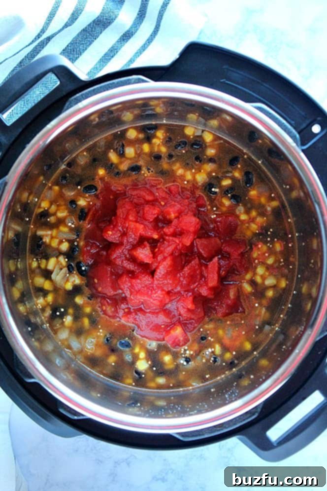 Quick and Zesty Instant Pot Mexican Quinoa 3 Overhead shot of quinoa, black beans and corn with diced tomatoes on top, in the Instant Pot.
