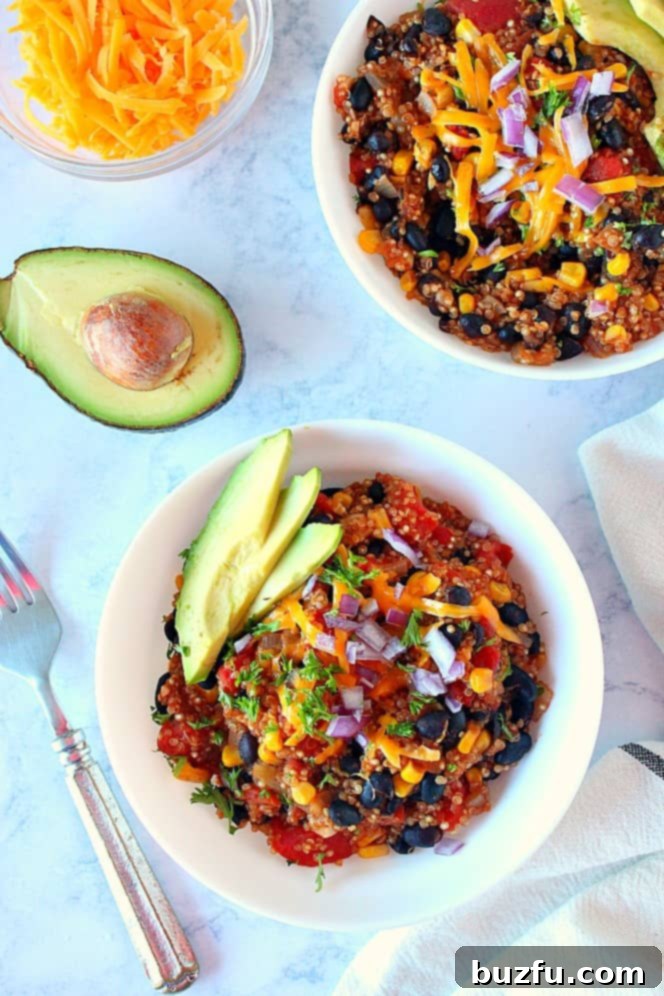 Quick and Zesty Instant Pot Mexican Quinoa 4 Overhead shot of two bowls of Mexican quinoa with shredded cheese, red onions and sliced avocados on top.