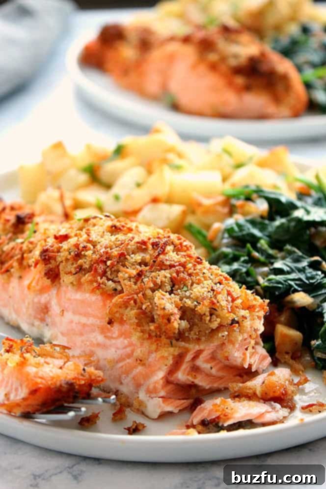 Side shot close up of salmon with breadcrumb crust, one piece on a fork.