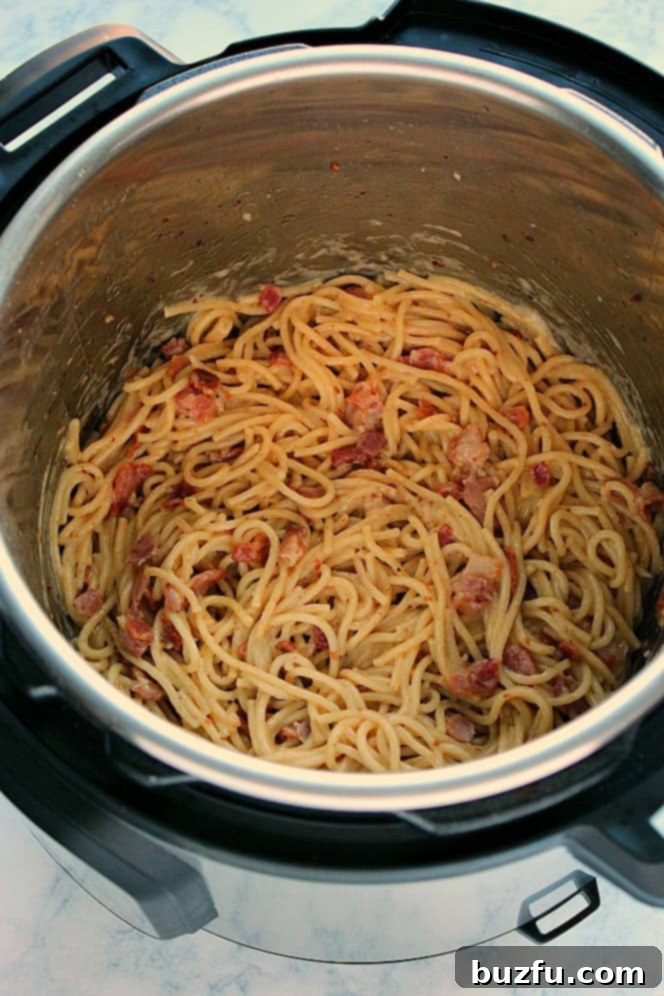 Overhead shot of creamy spaghetti carbonara garnished with fresh parsley and Parmesan cheese, served directly from the Instant Pot.