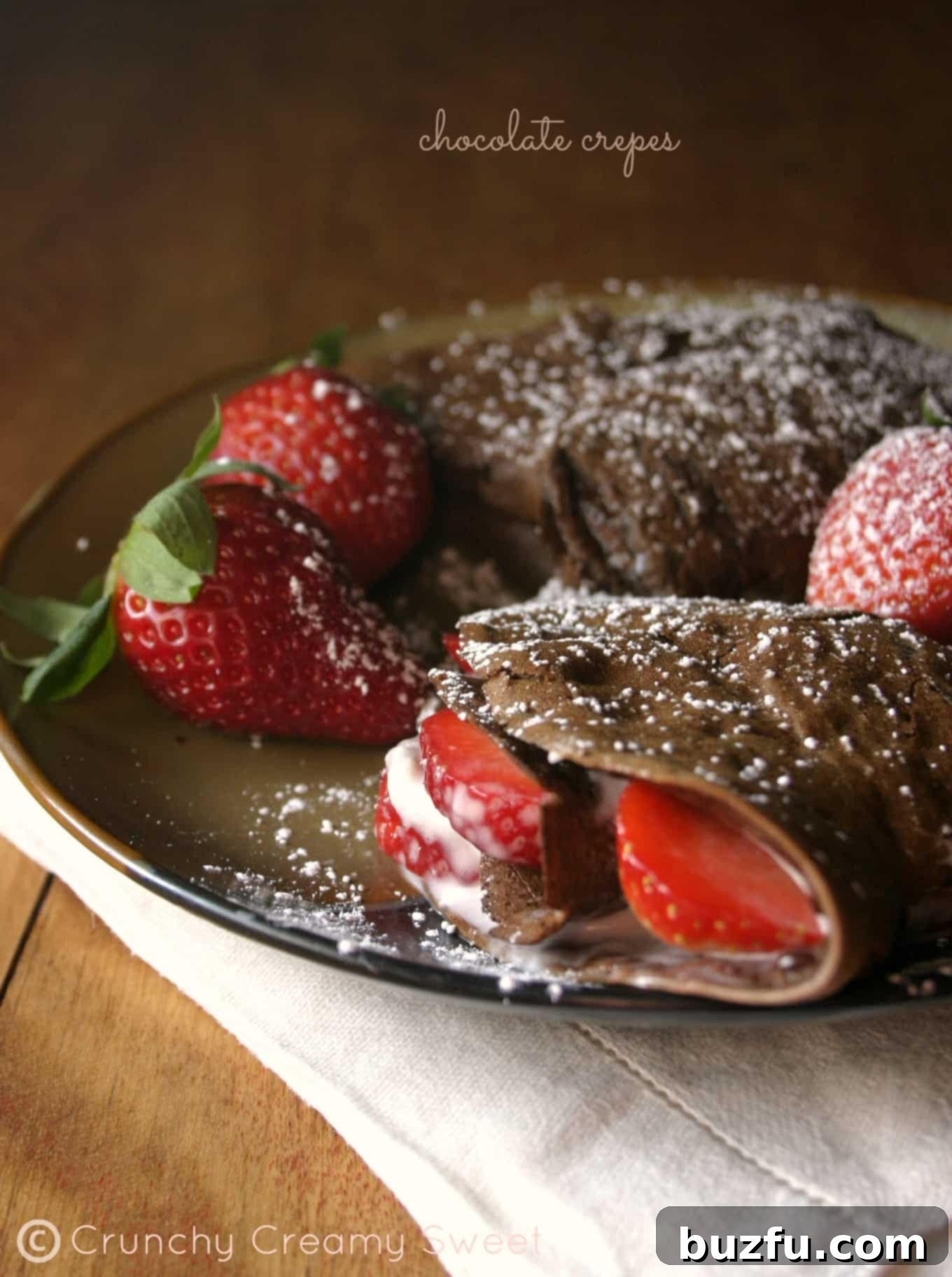 Gourmet Chocolate Crepes with Strawberries and Cream Cheese Filling Delicious chocolate crepes filled with cream cheese and fresh strawberries, perfect for an elegant breakfast or brunch.