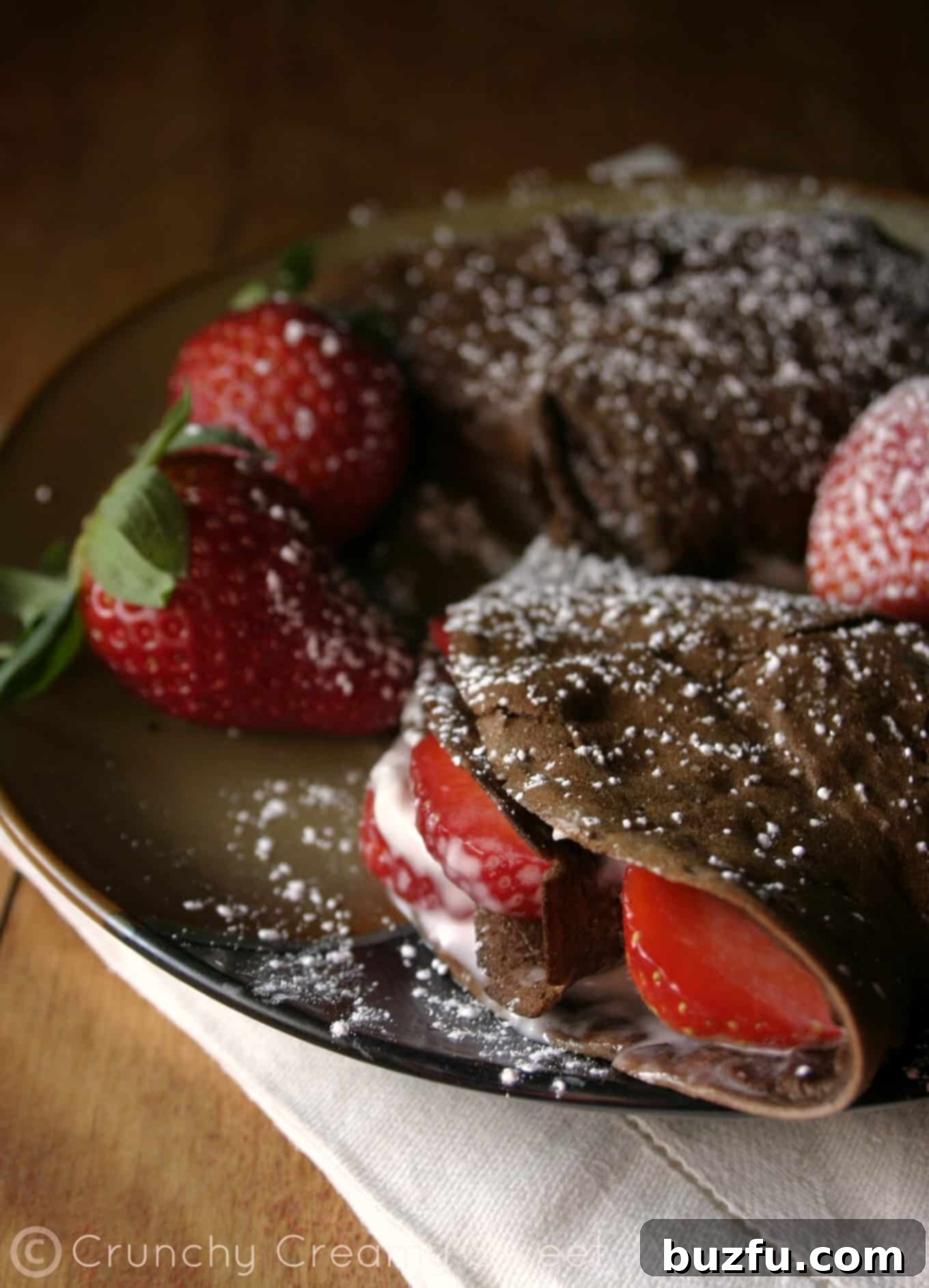 Freshly Made Chocolate Crepe with Strawberry and Cream Cheese Up-close shot of a perfectly cooked chocolate crepe with fresh strawberries and cream cheese, ready to be folded.