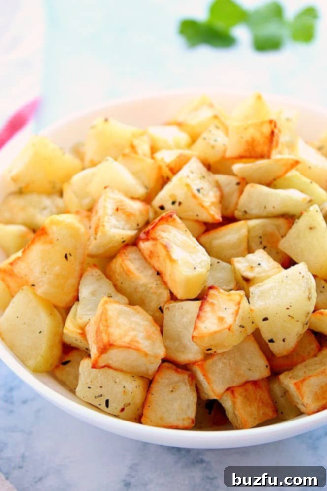 Air Fryer Roasted Potatoes: Quick, Easy, Healthy Side Dish Side shot of roasted potato chunks in white bowl. Golden brown and perfectly seasoned.