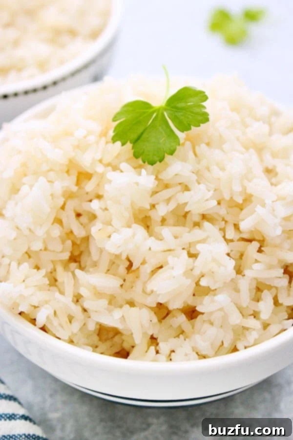 Perfectly Fluffy Instant Pot Rice, Every Time. Cooked rice in a white bowl with a parsley leaf on top.