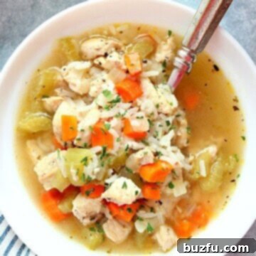 Instant Pot Chicken and Rice soup in white bowl with spoon.