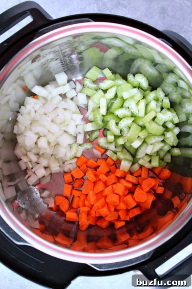 Overhead shot of chopped onions, carrots and celery sautéing in the Instant Pot.