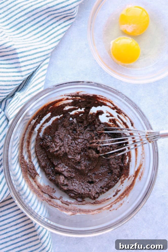 How to make easy chocolate lava cake in the Instant Pot. Overhead shot of chocolate sugar mixture in glass bowl, eggs in another bowl.