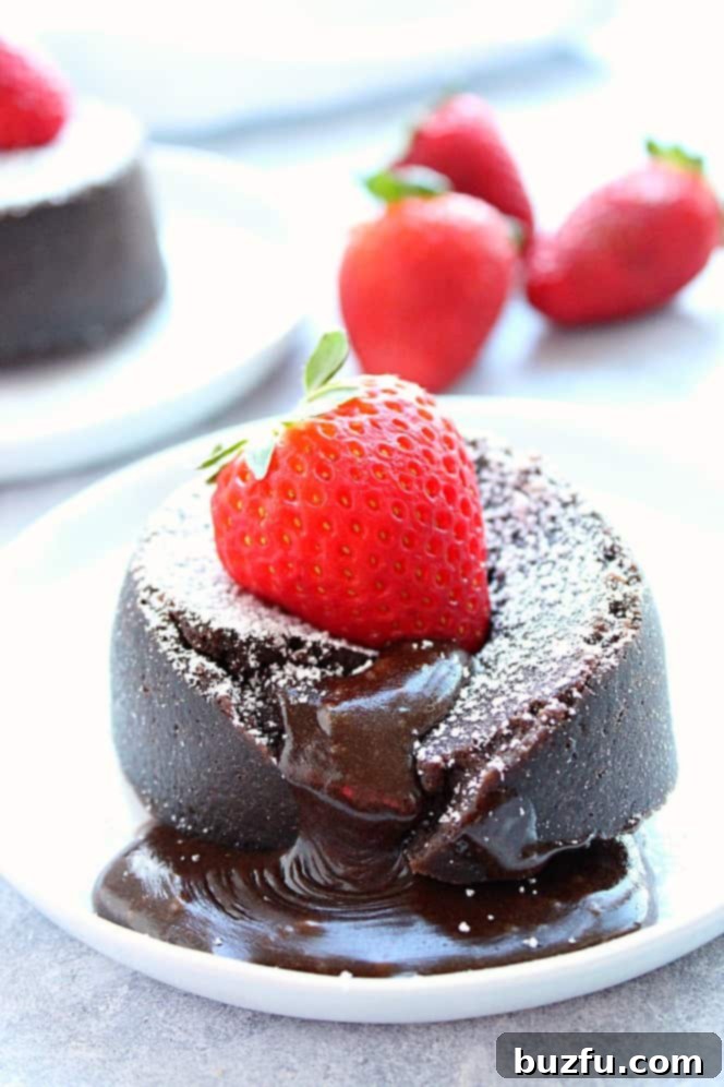Instant Pot Chocolate Lava Cake Recipe - very easy and decadent molten lava cakes cooked in the Instant Pot pressure cooker, ready in less than 20 minutes. The gooey, fudgy center is irresistible! Side shot of chocolate lava cake with strawberry on top.