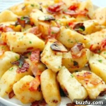 Polish Potato Dumplings (Kopytka) served on a white plate with savory toppings.