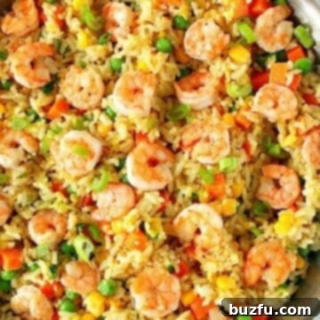 Fried rice with shrimp in a stainless steel skillet.