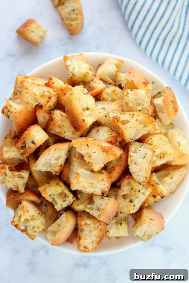 Overhead shot of homemade croutons in white bowl.