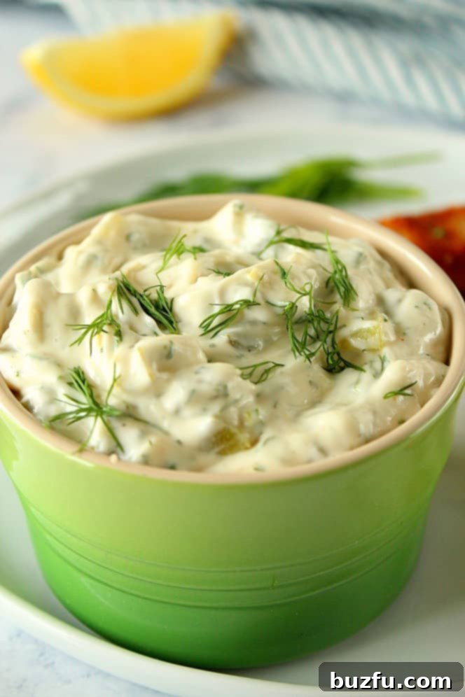 A close-up shot of creamy homemade tartar sauce in a vibrant green bowl, ready to be served.