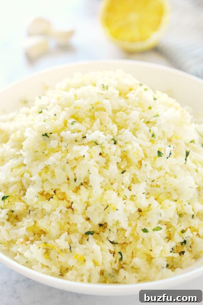 Flavorful Lemon Garlic Cauliflower Rice - A Quick and Healthy Side. Close up shot of lemon garlic cauliflower rice in white bowl.