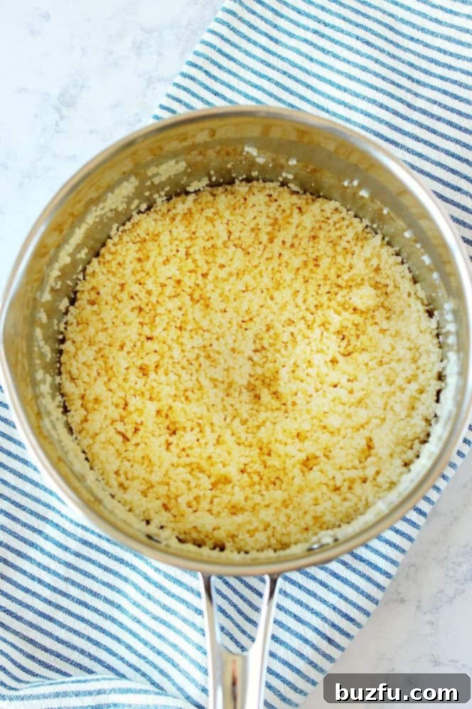 Overhead shot of perfectly cooked and fluffed couscous in a pot, ready to serve.