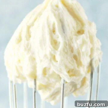 The Perfect Vanilla Frosting 3 White frosting on a whisk.