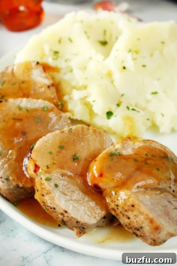 The Best Instant Pot Pork Tenderloin with Honey Garlic Sauce Side shot of perfectly cooked slices of pork tenderloin on a plate, highlighting its tenderness.