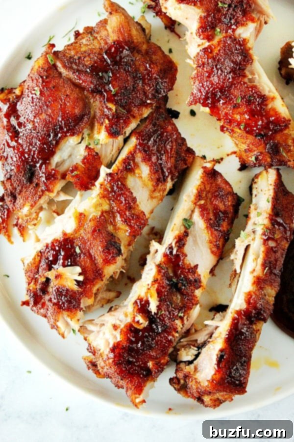 Overhead shot of perfectly cut and sauced ribs on a rustic wooden plate, ready to be served.