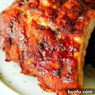 Close up shot of cooked baby back ribs on plate.