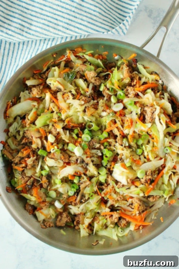 Overhead shot of a rich, savory egg roll filling cooking in a skillet, showcasing the delicious blend of meat and vegetables.