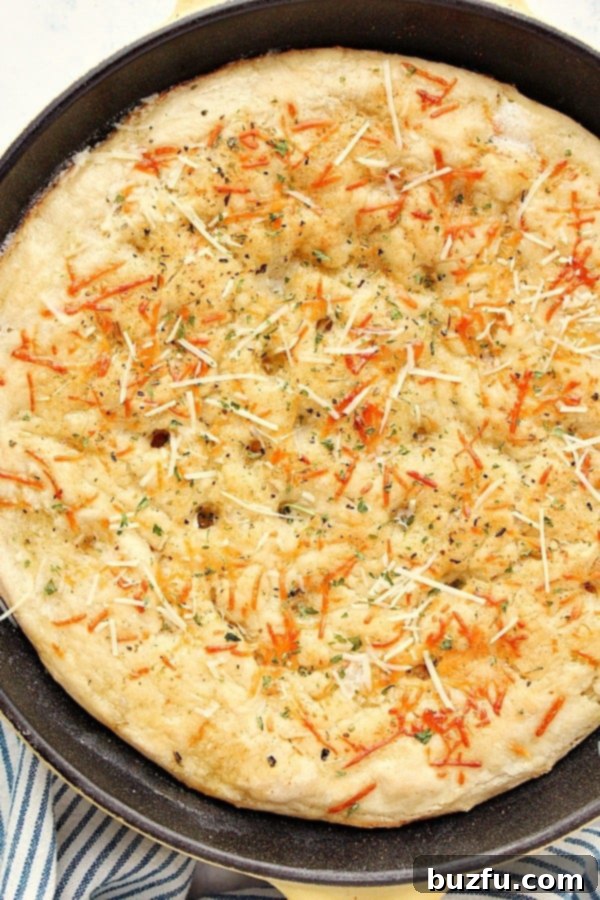 One-Hour Skillet Focaccia - the best recipe for focaccia! Easy yeast bread that's baked in a skillet and takes only 1 hour to make! Check out our tips on making a perfect focaccia every time! Skillet Focaccia with Parmesan cheese on top.