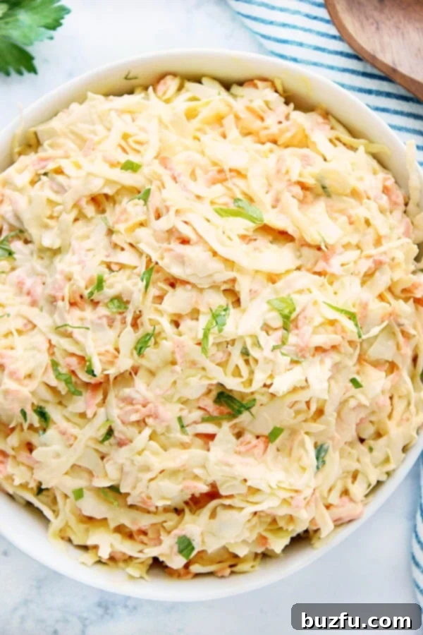 Creamy Coleslaw in a large white salad bowl, ready to be served at a potluck or BBQ dinner.