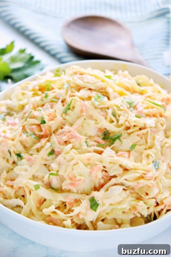 Creamy Coleslaw in a elegant white bowl on a marble countertop, perfectly garnished.