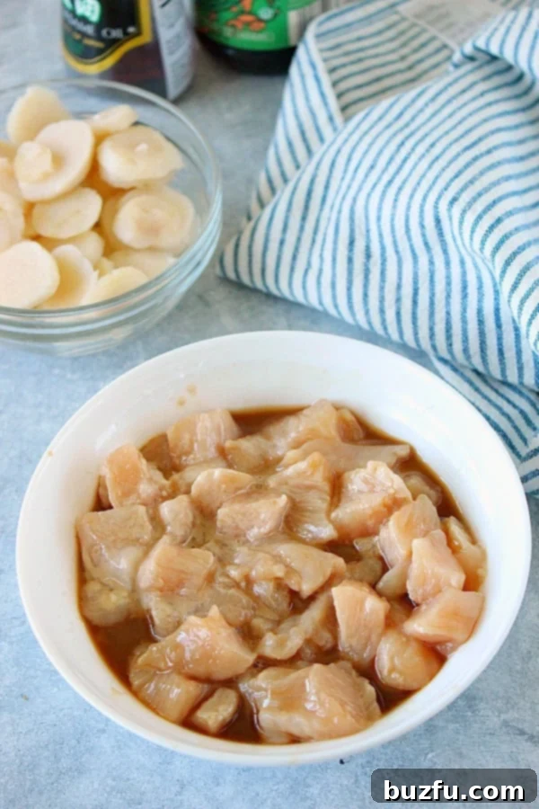 Bite-sized chicken pieces marinating in a bowl, ready for Moo Goo Gai Pan stir fry.
