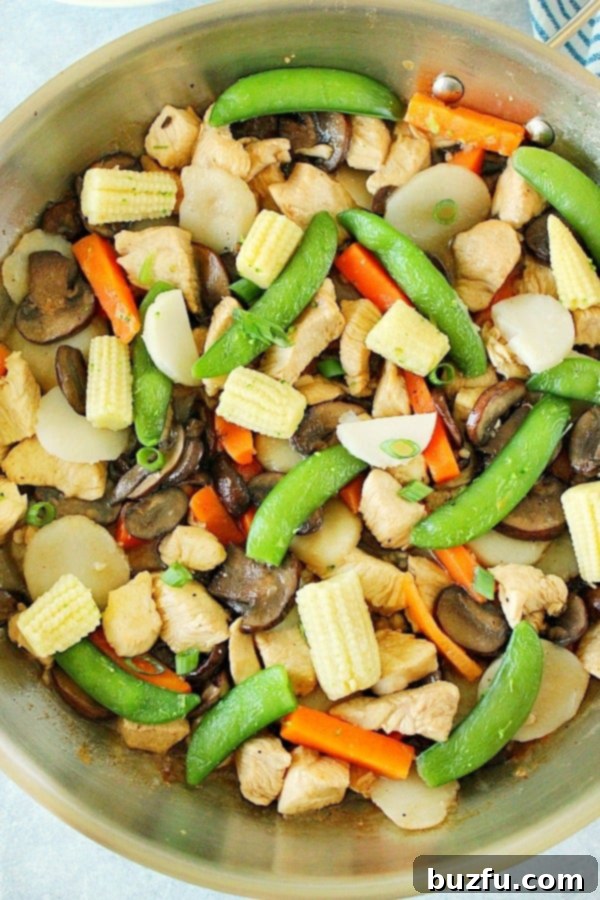 Overhead shot of freshly cooked Moo Goo Gai Pan, vibrant with chicken, mushrooms, and vegetables in a skillet.