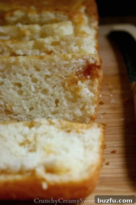 Classic Quick Bread Recipe - traditional flat top sweet bread with apricot jam swirl. Close up shot of several slices of apricot jam swirl quick bread on a wooden cutting board, highlighting the moist texture.