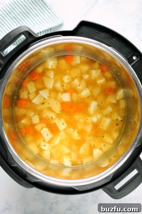 Chopped vegetables and potatoes in the Instant Pot, ready for pressure cooking.