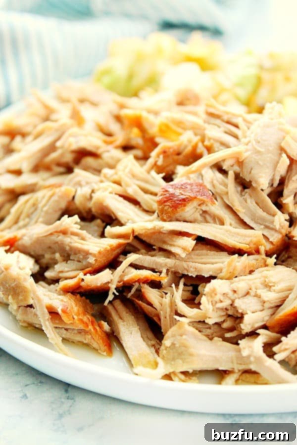 Instant Pot Kalua Pork on a white plate with cabbage on the side. A generous portion of smoky, shredded pork is served alongside tender, steamed cabbage, ready to be enjoyed.