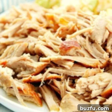 Instant Pot Kalua Pork on a white plate with cabbage on the side. A close-up shot of the shredded, smoky pork.