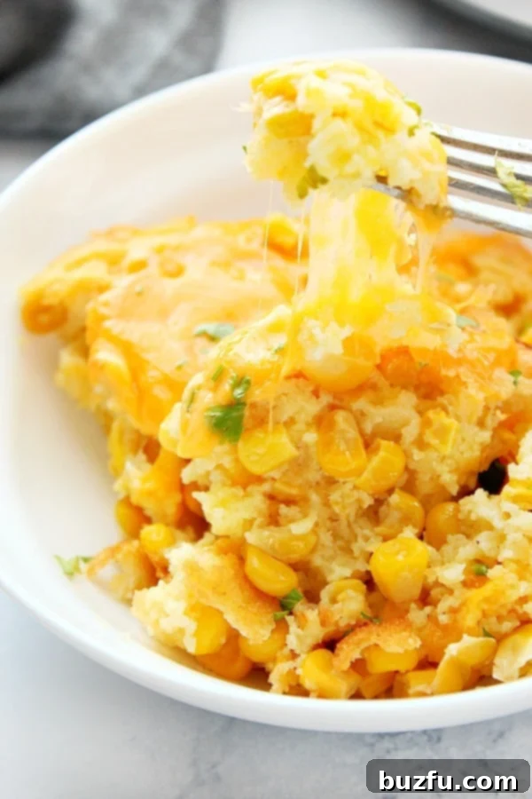 How to make cheesy corn casserole with sweet corn and cornbread mix. Cheesy Corn Casserole in a bowl.