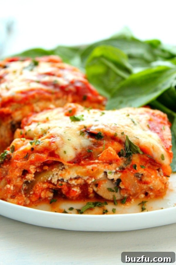 How to make a delicious low-carb lasagna with vegetable noodles for a healthy meal. A generous piece of vegetable lasagna served on a white plate with fresh spinach.