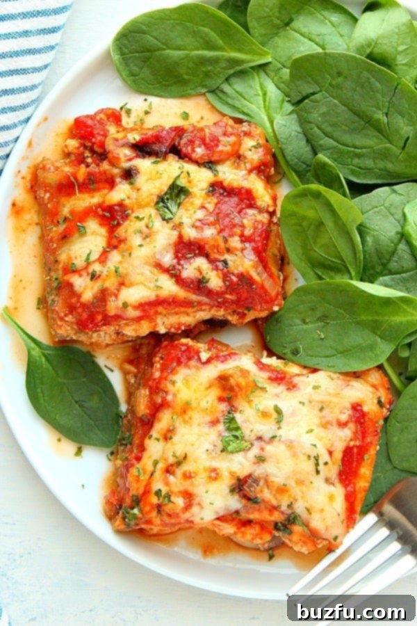 Make the best vegetarian lasagna with tender eggplant noodles and a rich mushroom pepper sauce. Two pieces of freshly baked Eggplant Lasagna on a white plate, garnished with fresh herbs.