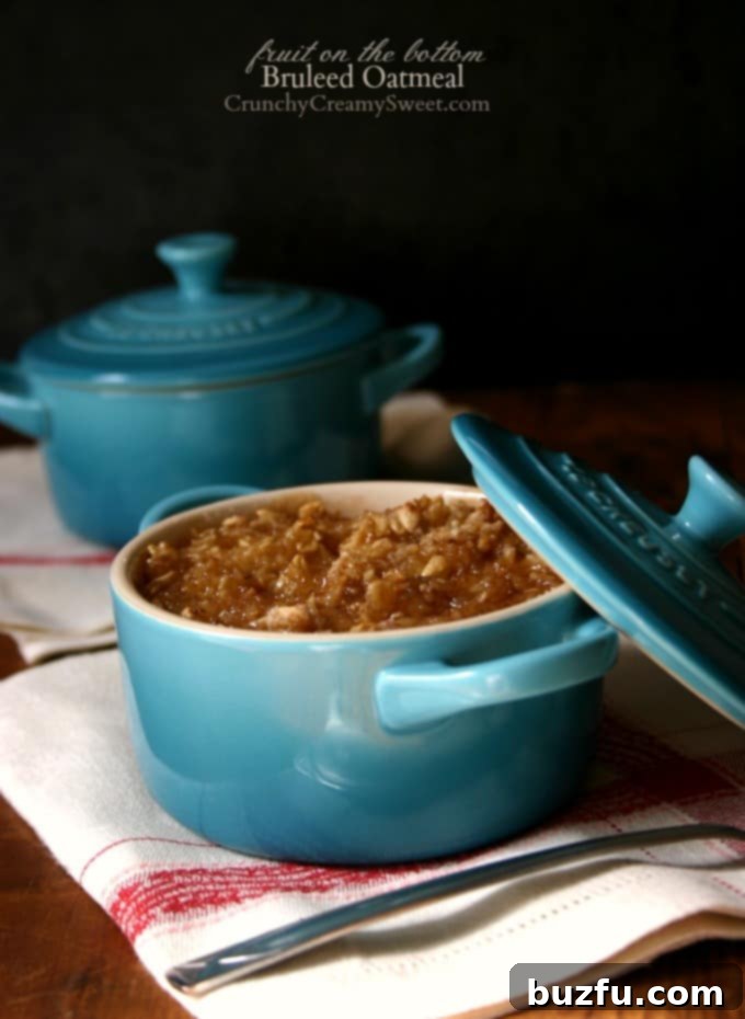Fruit on the Bottom Bruleed Oatmeal - easy breakfast idea with oats. Bake oatmeal with fruit filling on the bottom and toasted sugar topping. Side shot of baked oatmeal in ramekins with lids, showing a golden-brown bruleed topping and a glimpse of fruit filling.