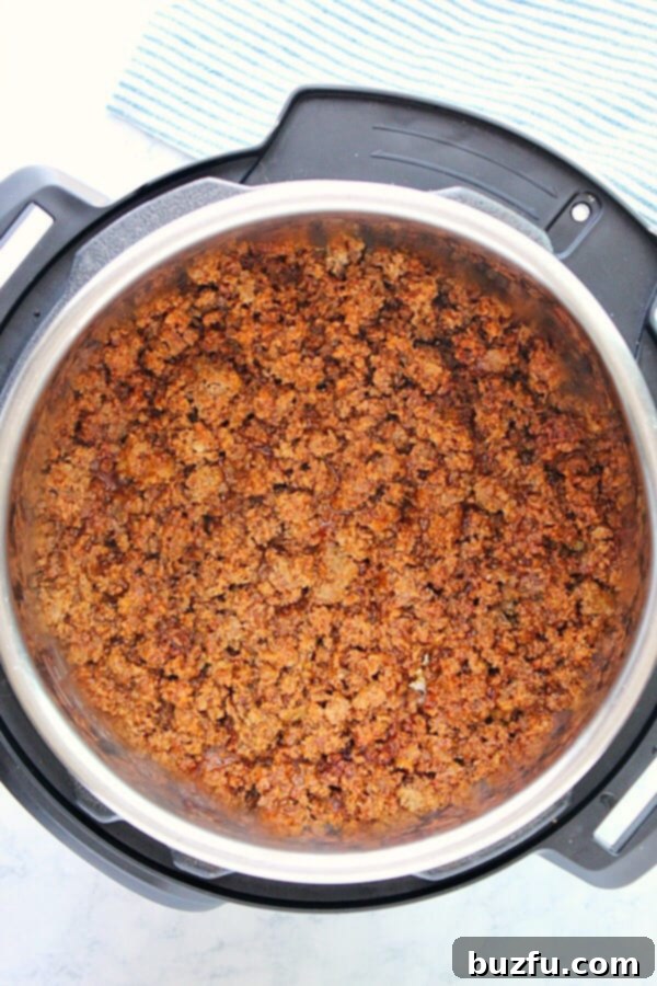 Instant Pot Taco Meat simmering inside the pressure cooker.
