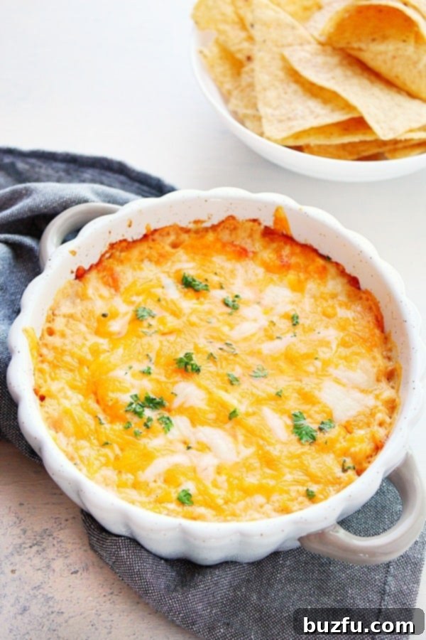 Hot Crab Dip in a round baking dish, garnished with fresh herbs.