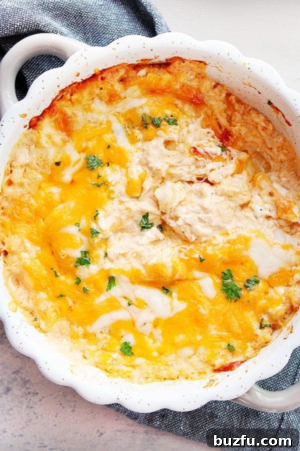 Baked Hot Crab Dip in dish, with melty cheese and steam rising.