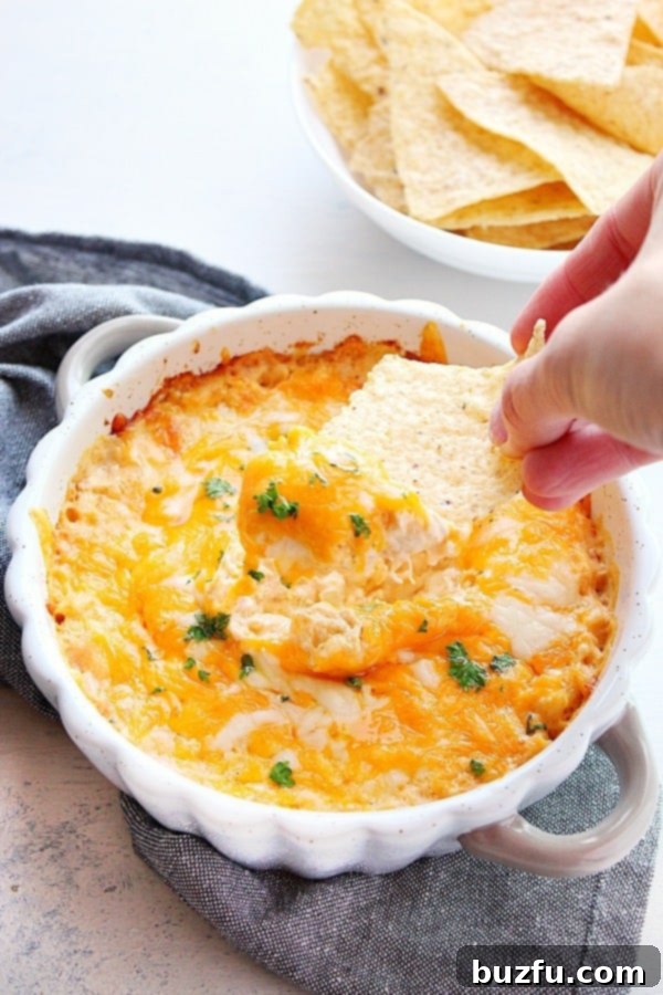 Hot Crab Dip with a tortilla chip dipped in, showing the creamy texture.